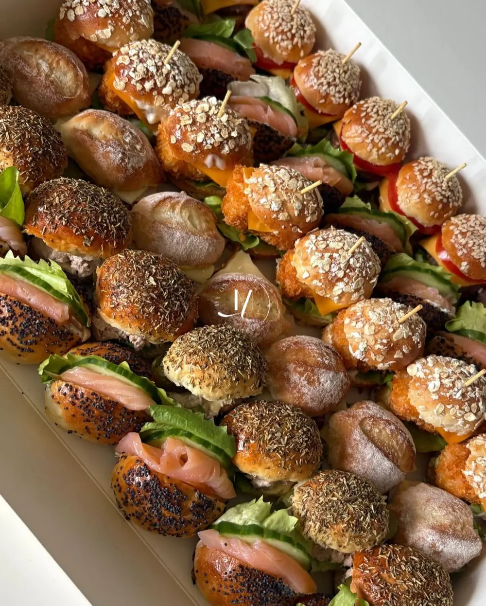Mini burgers au sésame, navettes saumon-concombre et pains aux herbes
